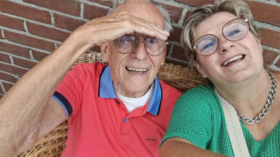 Two people laughing together on a sunny terrace at De Gelukshoeve