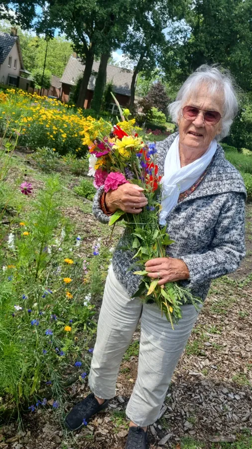 A woman with a freshly picked bouquet in the flower garden
